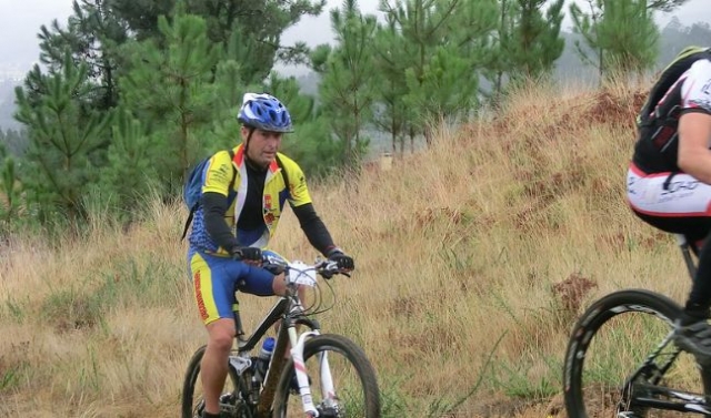 hombre en una mountain bike con arboles de fondo.jpg